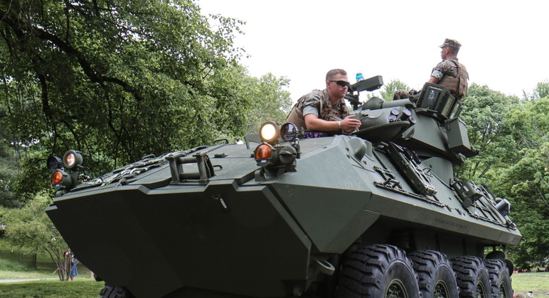 Two Marines sit atop the Light Armored Vehicle 25 (LAV 25).