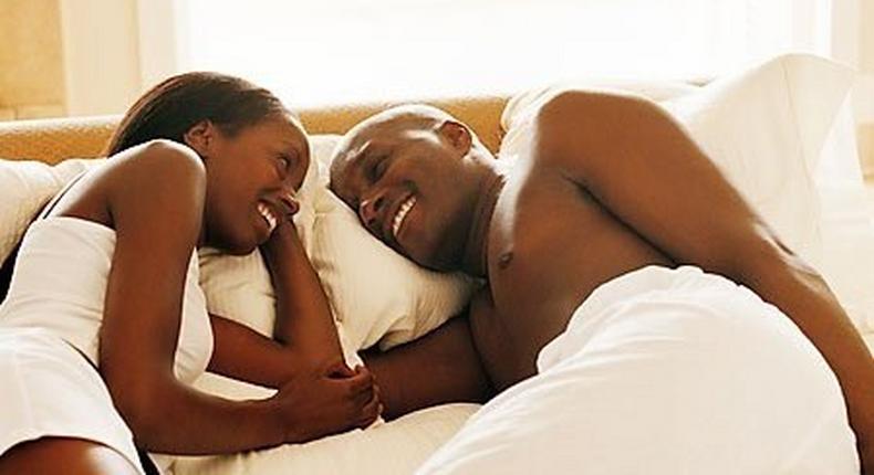Black couple talking in bed