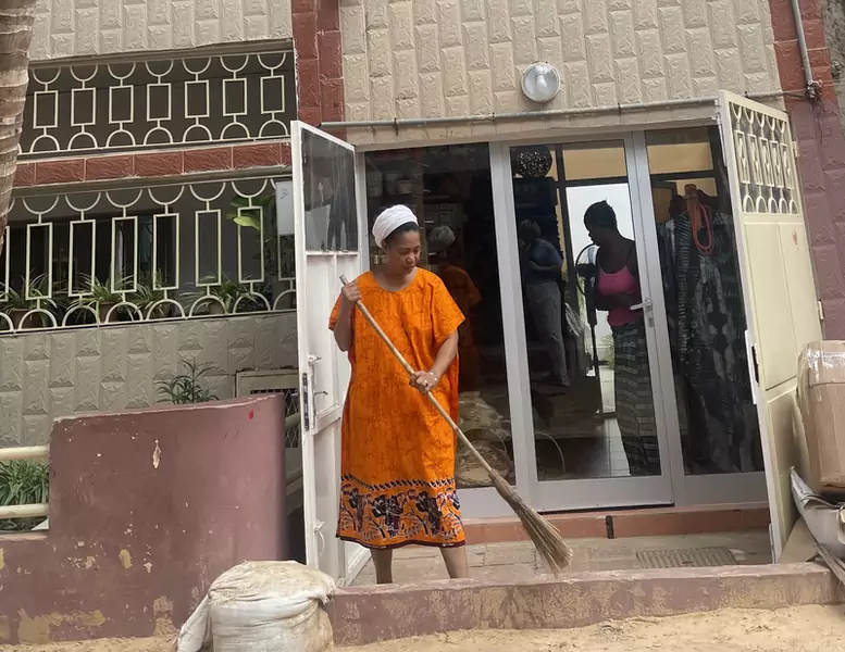 Kobieta zamiatająca wejście do sklepu w centrum Dakaru.