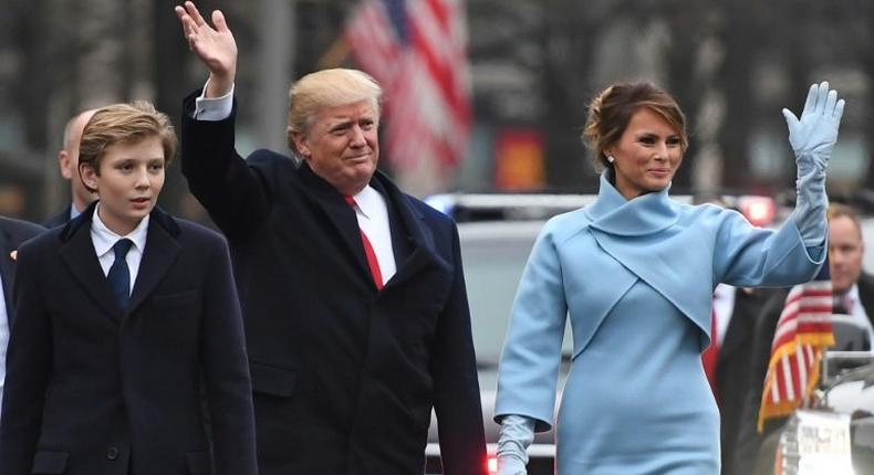 US President Donald Trump and First Lady Melania Trump walk the inaugural parade route with son Barron on Pennsylvania Avenue in Washington, DC