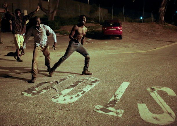 African migrants react as they arrive at the CETI, the short-stay immigrant centre, after crossing t