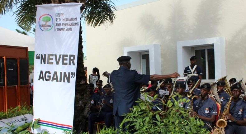 This picture shows a banner reading Never Again is seen as a police band performs during the Truth and Reconciliation and Reparation Commission, at the Dune's Resort, in Kotu, near Bajul, on October 15, 2018