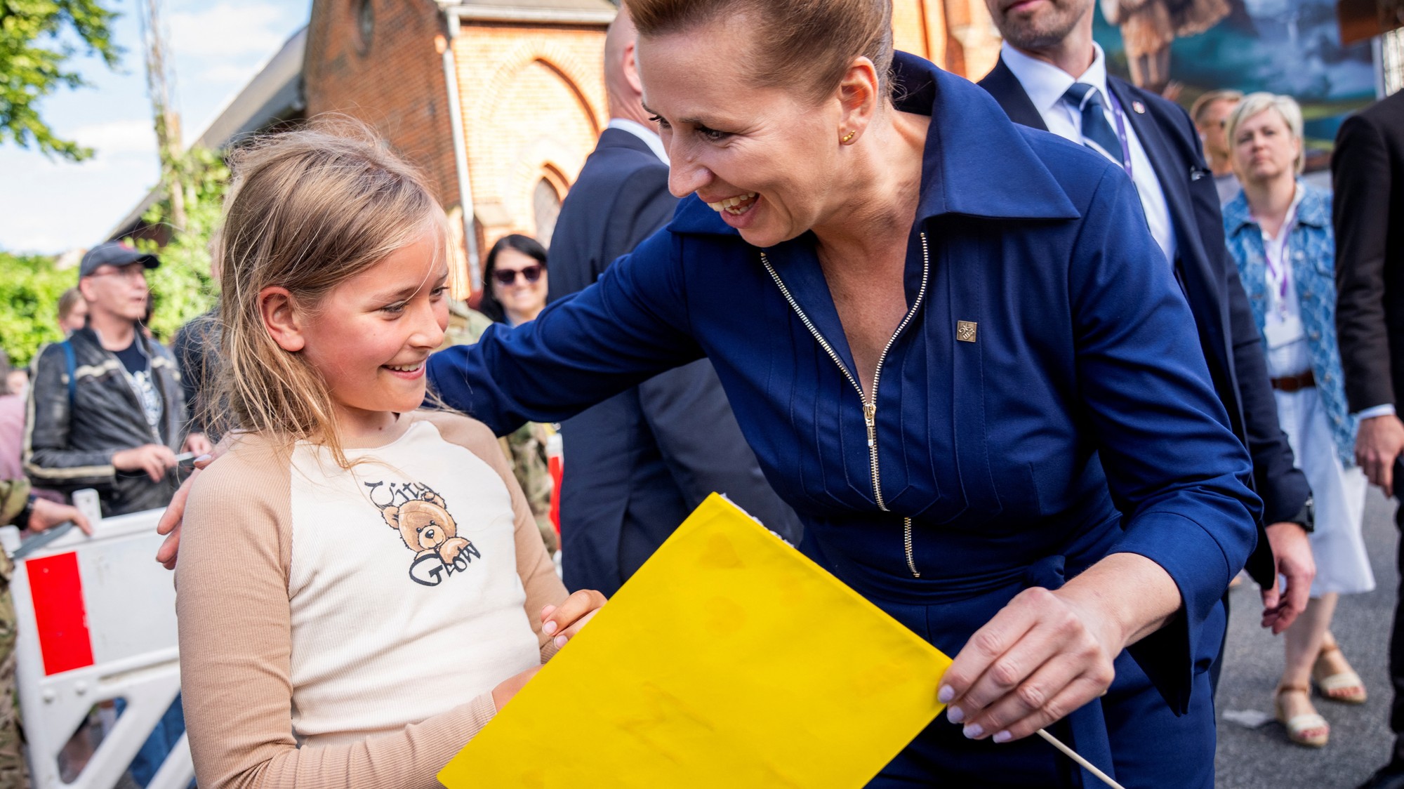 Premiérka Mette Frederiksenová dostáva vlajku od 9-ročnej Mily počas prechádzky v Radničnej záhrade na radnici v Aarhuse.
