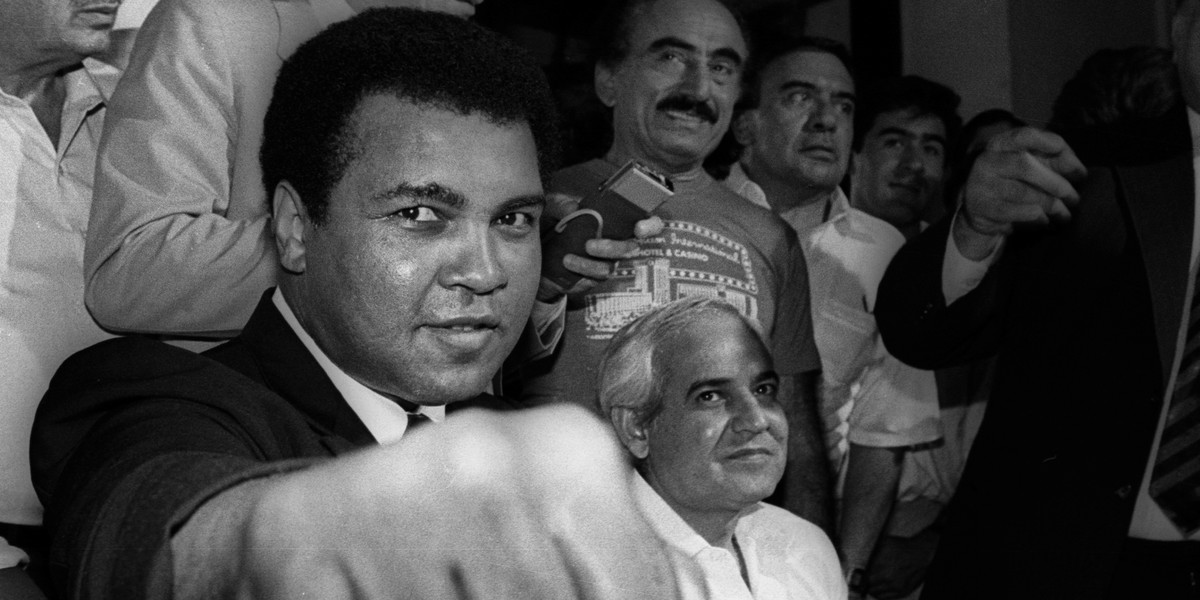 A smiling Muhammad Ali shows his fist to reporters during an impromptu press conference in Mexico City July 9, 1987.