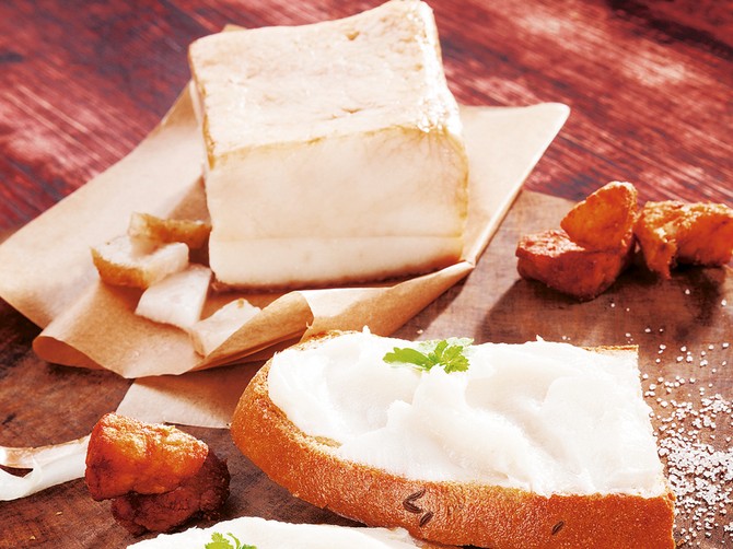 105625_stockphotobreadsliceswithlardporkscratchingsandbacononwoodencuttingboardonbrownbackground246467617