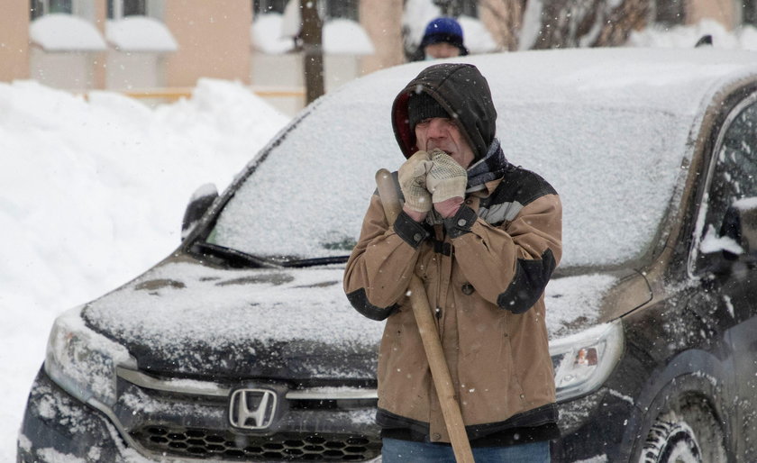 Workers remove snow in a street in Moscow