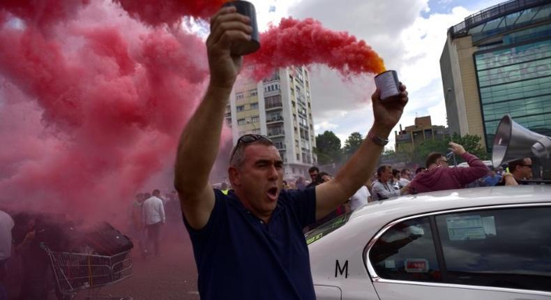 A taxi driver brandishes smoke canisters as he protests in Madrid