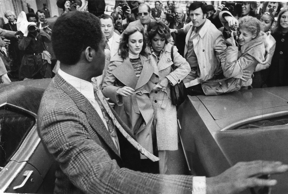 Patty Hearst odprowadzana przez policjantów do samochodu po wizji lokalnej w apartamencie. Pokazywała podczas niej funkcjonariuszom szafę, w której była przetrzymywana przez porywaczy. (1976 r.)