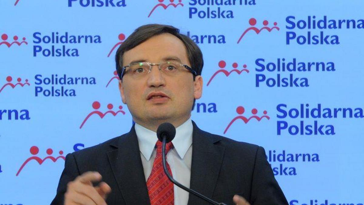 Zbigniew Ziobro w tle logo Solidarna Polska