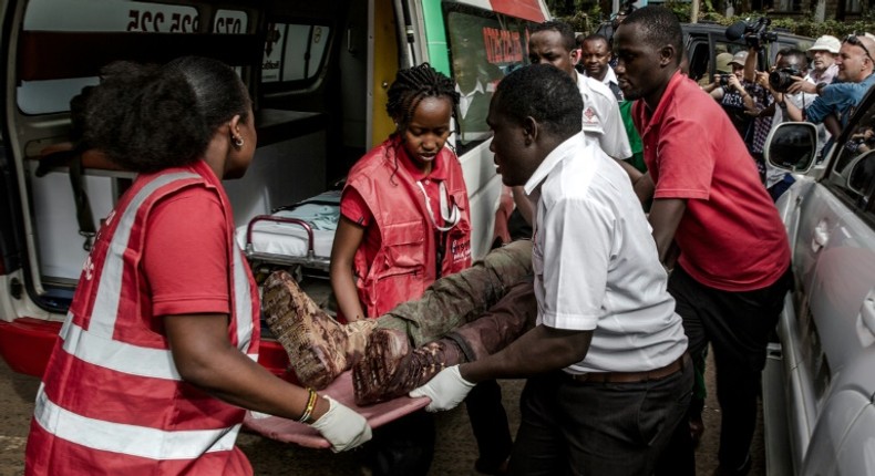 An injured member of the security forces is evacuated from the scene