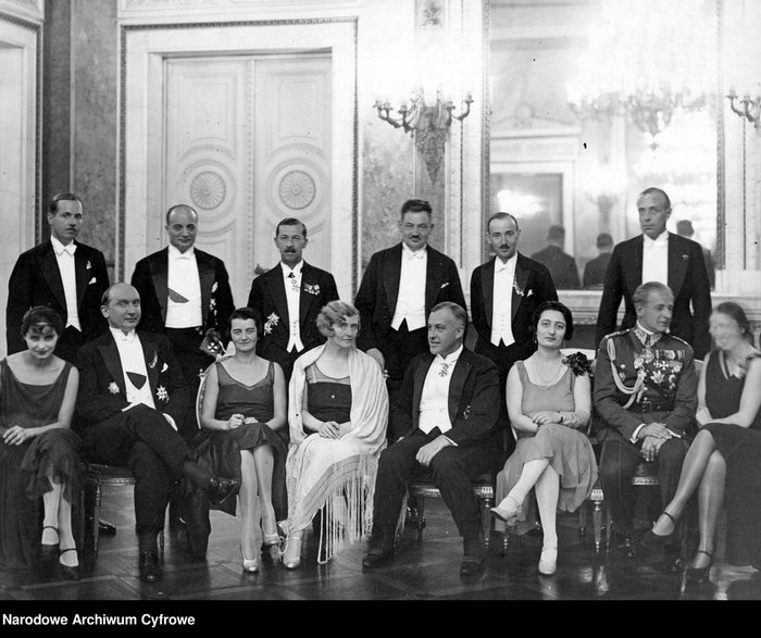 Uczestnicy rautu w 1929 r. Widoczni m.in. minister spraw zagranicznych August Zaleski (siedzi, drugi z lewej) z żoną (czwarta z lewej), Marta Rydz (trzecia z lewej), pułkownik Bolesław Wieniawa-Długoszowski (siedzi, drugi z prawej), z żoną (pierwsza z lewej), komisarz rządu na m.st. Warszawę Władysław Jaroszewicz (siedzi, czwarty z prawej), szef Protokołu Dyplomatycznego Ministerstwa Spraw Zagranicznych Karol Romer (stoi, drugi z lewej), dyrektor Departamentu Ogólnego Ministerstwa Spraw Zagranicznych Marian Szumlakowski (stoi, trzeci z lewej), naczelnik Wydziału Wschodniego w Departamencie Polityczno-Ekonomicznym Ministerstwa Spraw Zagranicznych Tadeusz Hołówko (stoi, trzeci z prawej), dyrektor Departamentu Administracyjnego Ministerstwa Spraw Zagranicznych Wacław Jędrzejewicz (stoi, drugi z prawej).