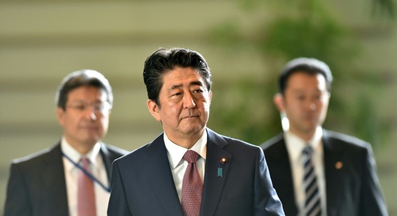 Japanese Prime Minister Shinzo Abe (C) has seen public support rates plummet in the past few months over an array of political troubles