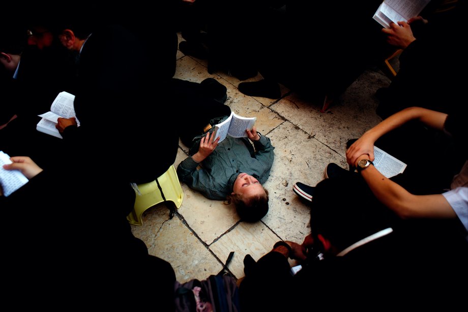 A Hasidic child reads from the Book of Lamentations during a prayer service at the Western Wall for the holiday of Tisha B'Av.