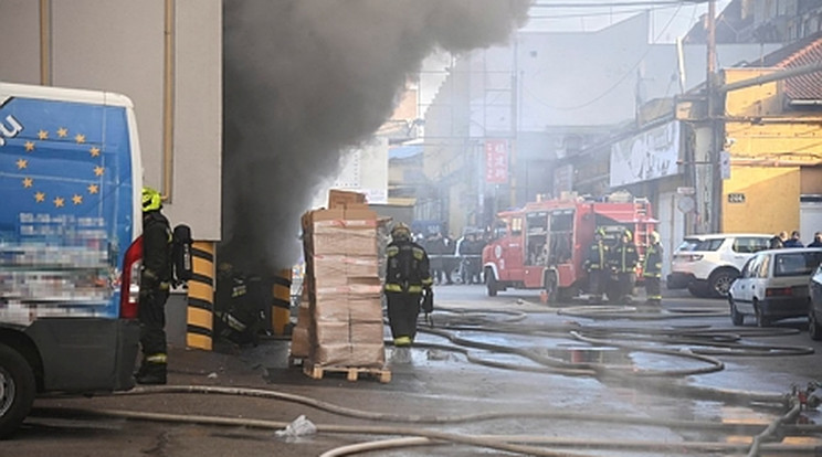 Füst gomolyog egy épületből a főváros VIII. kerületében, a Golgota téren, miután tűz ütött ki egy többszintes irodaház alagsori raktárában 2022. január 12-én. Az épületet kiürítették/ Fotó: MTI/Mihádák Zoltán