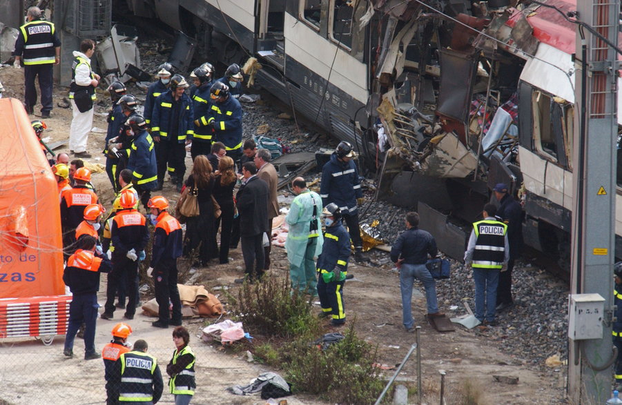Ratownicy przeszukujący wrak pociągu podmiejskiego po ataku z 11 marca 2004 r.