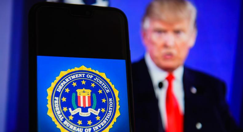 The Federal Bureau of Investigation (FBI) logo displayed on a mobile phone with former President Donald Trump in the background.Omar Marques/SOPA Images/LightRocket via Getty Images