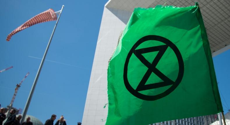 Extinction Rebellion, whose logo is seen here at a recent protest near Paris, organises acts of civil disobedience to draw attention to climate warming