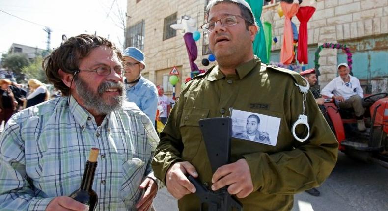 A Jewish settler dressed in military fatigues wears a portrait of Elor Azaria, an Israeli soldier who shot dead a wounded Palestinian assailant, during a parade marking the Jewish holiday of Purim in Hebron on March 12, 2017