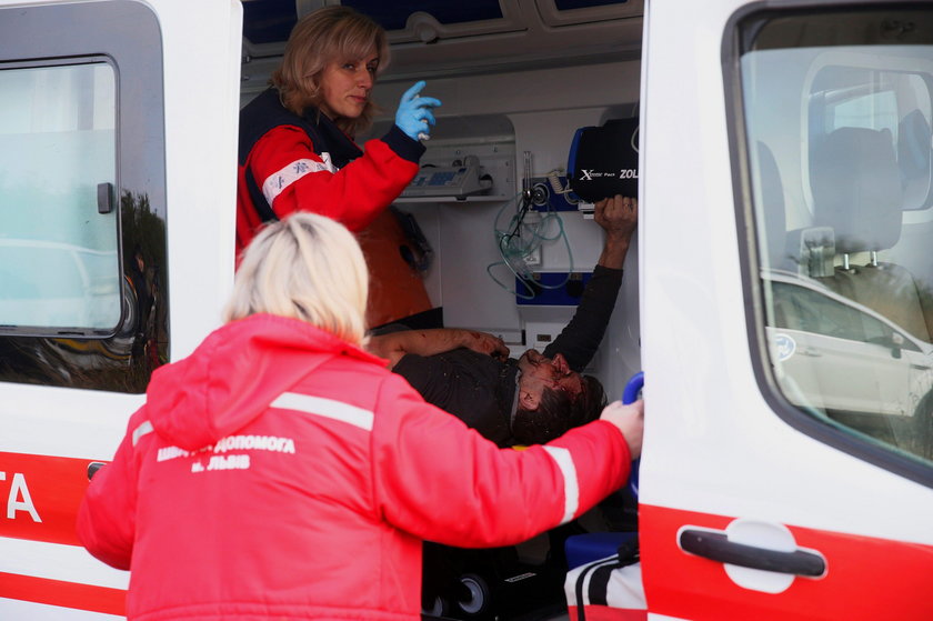 Medics assist a wounded person at the site of the Antonov-12 cargo airplane emergency landing in Lvi