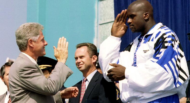 President Bill Clinton is saluted by basketball star Shaquille O'Neal during a visit to a youth center in Santa Ana, California, on September 22, 1995.