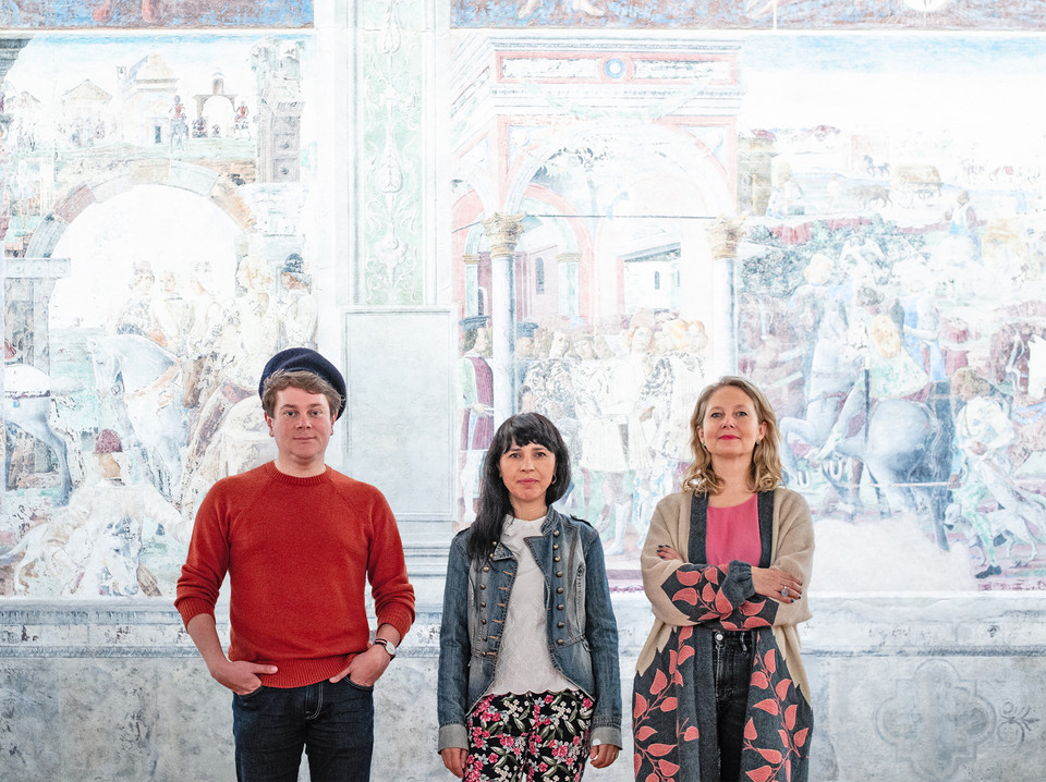 Zespół autorski wystawy "Przeczarowując świat" na tle fresków w Palazzo Schifanoia w Ferrarze (2021) 