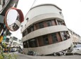 Crushed vehicles are seen under a building that was damaged after a powerful earthquake hit Tainan