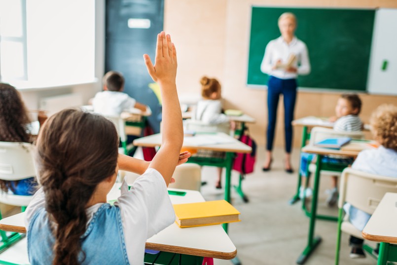 Nauczyciel Szkoła Rear,View,Of,Schoolgirl,Raising,Hand,To,Answer,Teachers,Question