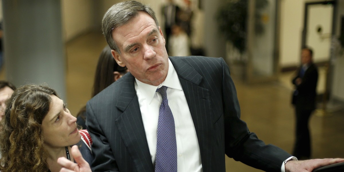 Senator Warner talks to reporters as he exits a Washington D.C. metro stop.