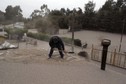 A man cleans the roof of his house at Ensenada town which is covered with ashes from Calbuco volcano