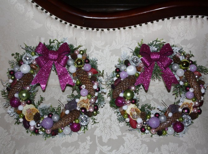 Wianki 'bliźniaki' w tonacji różowo-fioletowej z ozdobnymi kokardami, bombkami i szyszkami. Autorka: Marta Jarosińska-Mańka