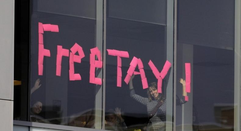 A makeshift sign goes up in an office window across from a courthouse where pop singer Taylor Swift is being sued for slander by a Denver DJ who she says groped her