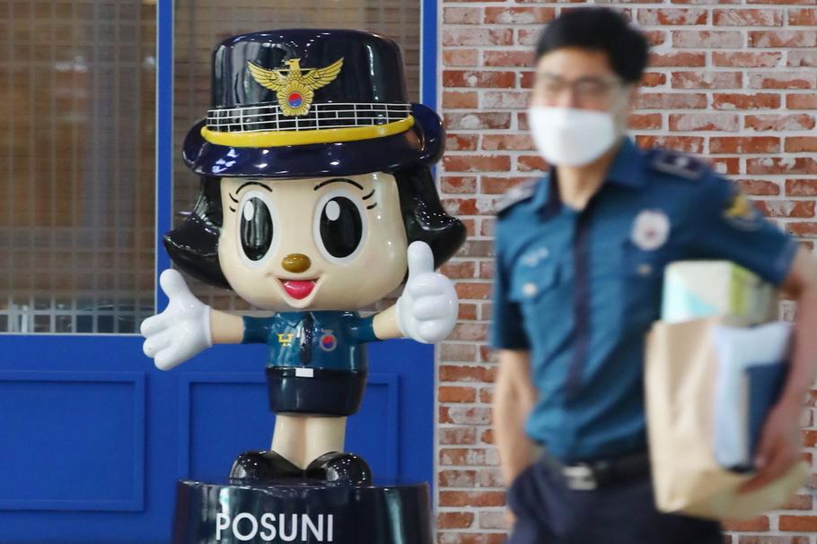 Koreański policjant obok maskotki służb policyjnych, Posuni. Seul, Korea Południowa