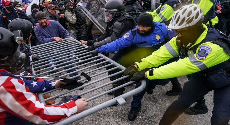 Trump supporters try to break through a police barrier during the Capitol riot.