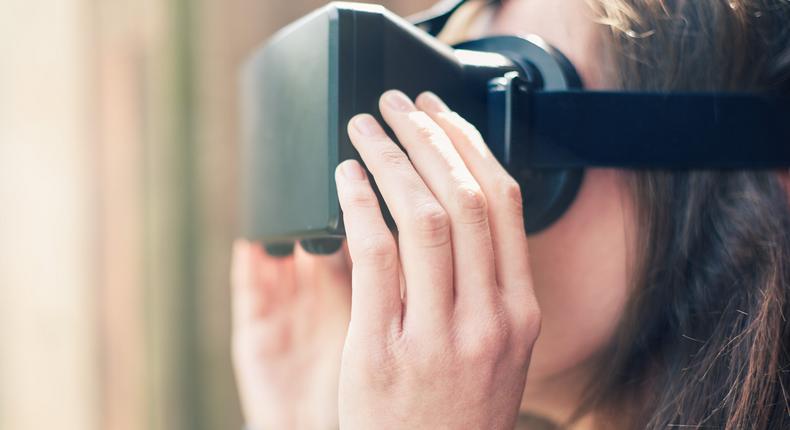 Stock image of a woman using a virtual reality headset.