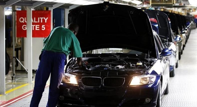 A worker inspects cars at BMW's manufacturing plant in Rosslyn, outside Pretoria, September 13, 2010. REUTERS/Siphiwe Sibeko
