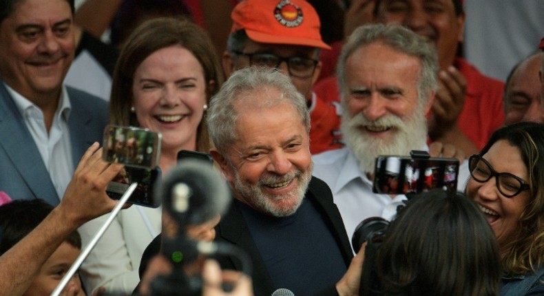 Former Brazilian president Luiz Inacio Lula da Silva smiles next to his girlfriend after leaving the federal police headquarters in Curitiba, where he was serving a sentence for corruption and money laundering