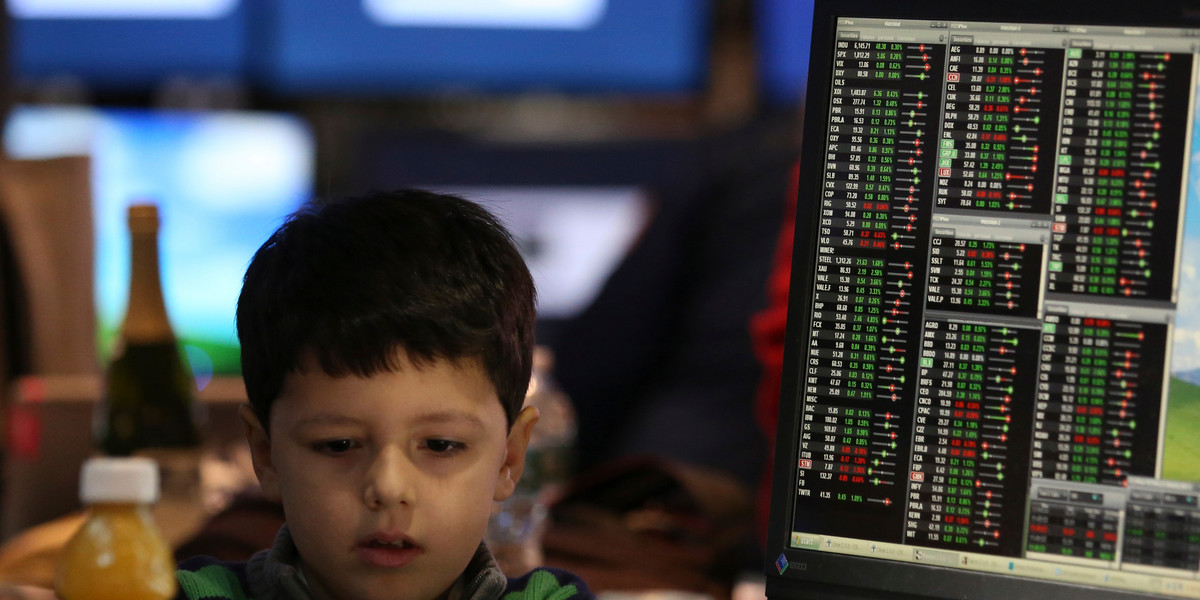 A young boy works at a post on the floor of the New York Stock Exchange.