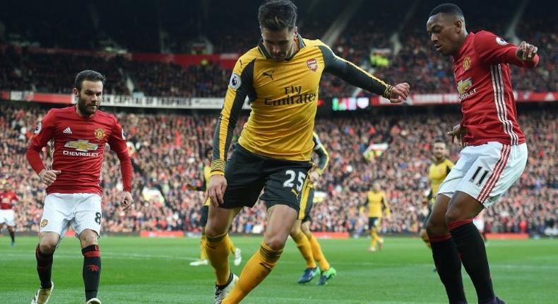 Arsenal's defender Carl Jenkinson (C) vies with Manchester United's striker Anthony Martial (R) and midfielder Juan Mata during the English Premier League football match November 19, 2016