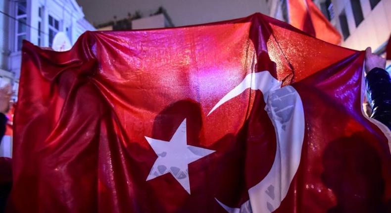 A protester waves a Turkish national flag during a demonstration in front of the Netherlands consulate in Istanbul on March 12, 2017