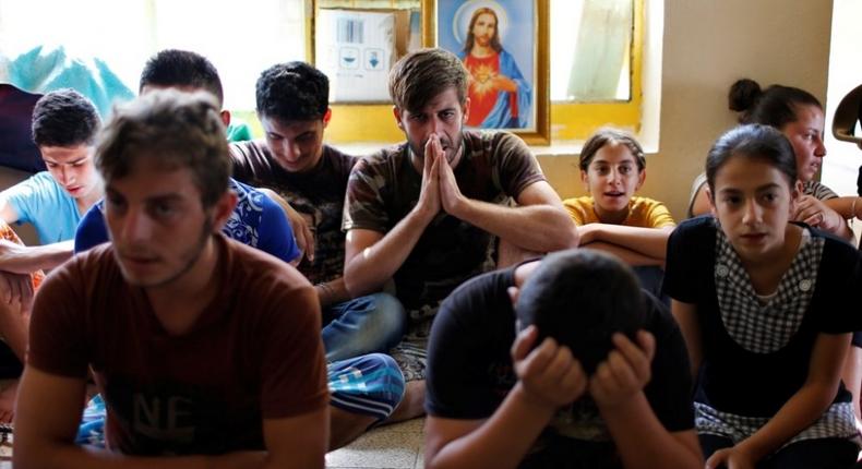 Displaced Iraqi Christians who fled from Islamic State militants in Mosul, pray at a school acting as a refugee camp in Erbil, Iraq, September 6, 2014.