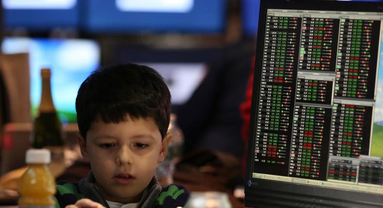 A young boy at a post on the floor of the New York Stock Exchange.