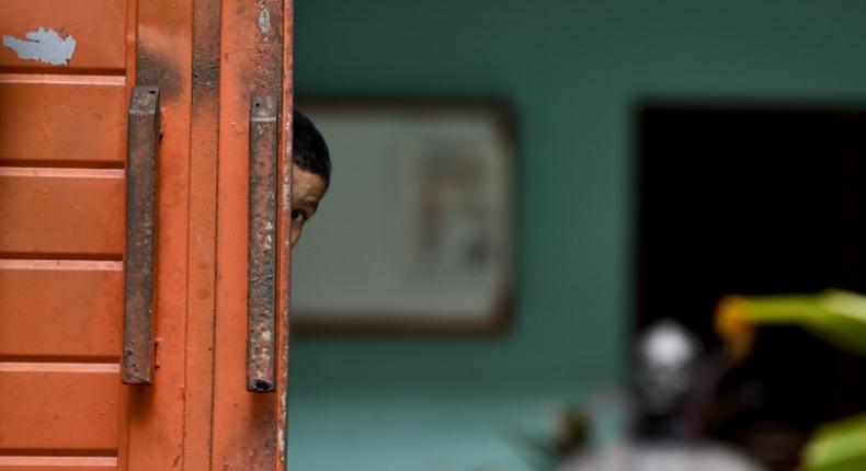 A Central American migrant child watches behind the main door of the Bethlehem Shelter in Tapachula, Chiapas state, Mexico