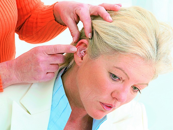 128610_stockphotoaudiologyspecialistfixinghearinghairtoanicemiddleagedwoman163451741