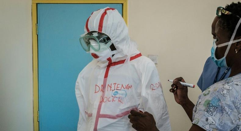 Protection: A doctor gets suited up for visiting a quarantine ward at Kenyatta National Hospital in Nairobi