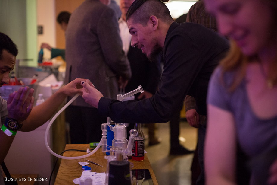 A viewing party attendee takes a hit from a marijuana vaporizer.