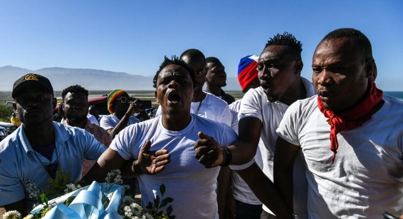 Protestors shout anti-government slogans outside a mass graveyard during the commemorative ceremonies of Haiti's 10th earthquake anniversary on the outskirts of Port-au-Prince, on January 12, 2020