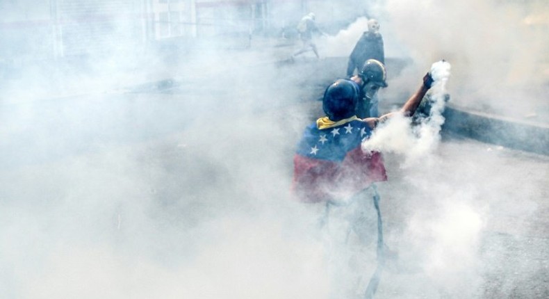 Opposition demonstrators clash with riot policemen during a health care personnel march in Caracas on May 22, 2017