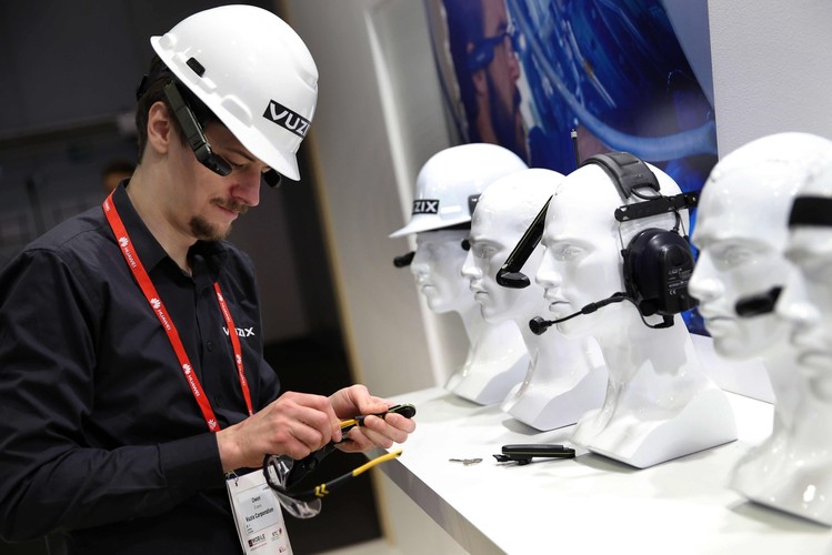 Członek personelu Vuzx demonstruje smart okulary z nadajnikiem. Producent określa ten sprzęt jako zaawansowany wyświetlacz nagłowny i system komunikacyjny. Okulary pozwalają na wizualizację informacji ze smartfona (Android i iOS). Jednak to nie wszystko co potrafią okulary firmy Vuzx. Za ich pomocą można rejestrować obraz, wyświetlać go, a nawet łączyć się z Internetem i uruchamiać aplikacje.