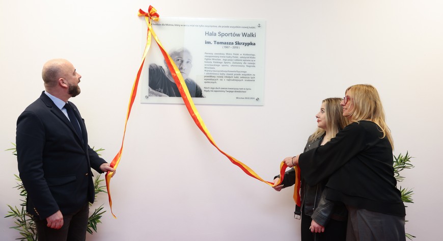Joanna Skrzypek, Oliwia Skrzypek i prezydent Jacek Sutryk odsłaniają tablicę pamiątkową. 