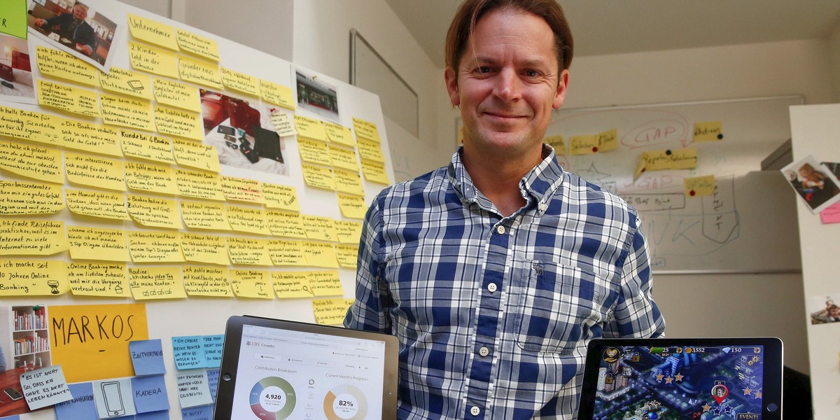 Dave Bruno, head of the innovation lab at Swiss bank UBS, poses with two tablet computers in his office in Zurich.